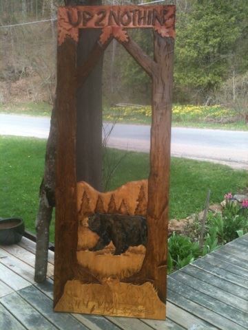 carved wood screen door with bear, trees and name of cabin