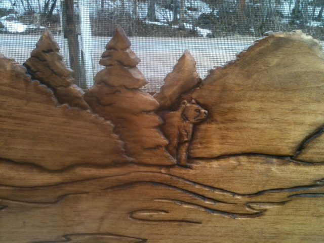 close up of bear carving on wood screen door