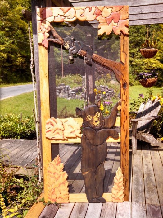 Wood screen door with hand carved bear and cub in a tree