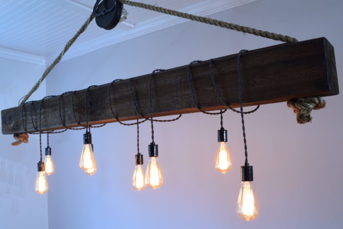 Wood beam chandelier with wrapped staggered bulbs